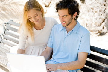 Young couple working on laptop and smiling