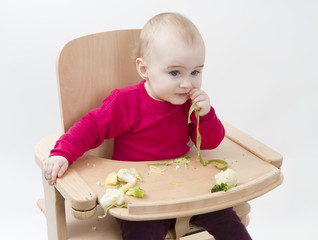 young child eating in high chair