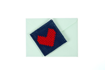 Green envelop with red knitted heart isolated on white backgroun