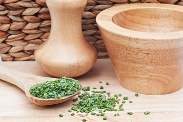 Chopped chives in rustic kitchen setting with wooden pestle and