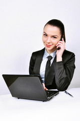 beautiful business woman with laptop talking by phone