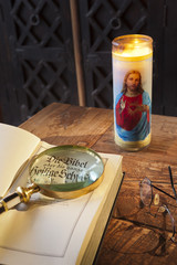 Deutsche Bibel auf altem Tisch mit Kerze