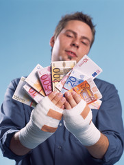 Mann, verletzt, hält Geld in Händen