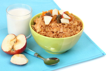 tasty cornflakes in bowl with dried fruits, glass of milk and