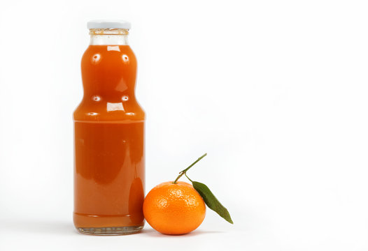 Juice in a glass bottle and tropical fruit on a white background