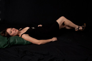 Obraz premium Lovely brunette woman in little black dress reclining