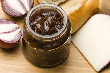 Onion jam in jar, goat's cheese and fresh bread