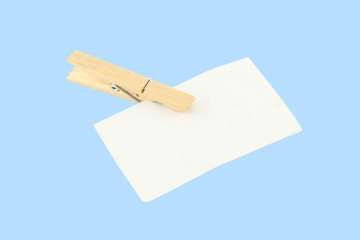 Side paper clip wooden clothespin on blue background.