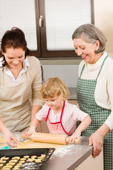 3 generations women rolling dough for baking
