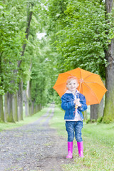 little girl with umbrella in spring alley