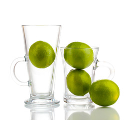 Fresh limes in glass cups isolated on white