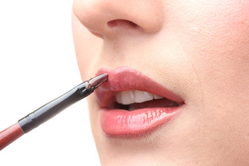 Naklejka premium beautiful woman applying lip gloss