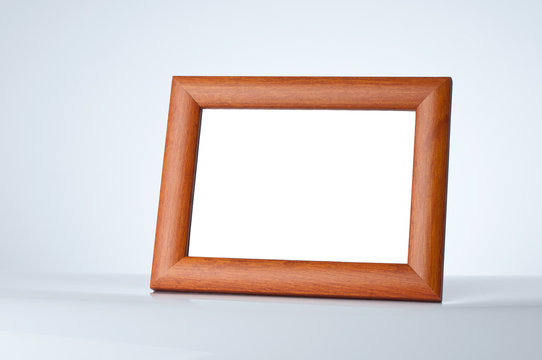 Blank wood picture frame on the table with place for your own te