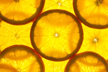 Foto op Plexiglas Plakjes fruit Sinaasappelschijfjes achtergrond / macro / verlichte achtergrond