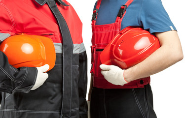 Two builders holding hardhats