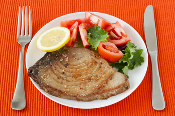 fried tuna with salad and lemon on the plate