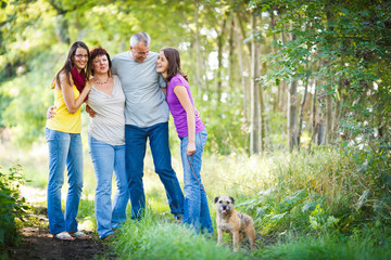 Fototapeta premium Family portrait - Family of four with a cute dog outdoors