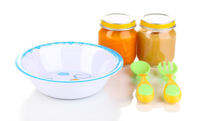 Jars of baby puree with plate, spoon and fork isolated on white