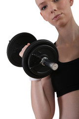 Fototapeta premium a young woman lifting a dumbbell