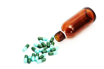 green pills and bottle ,isolated white.