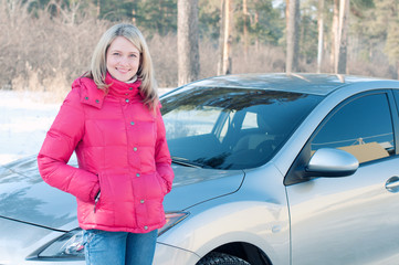 Young blonde standing in front of her car outdoors