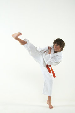 boy practicing karate on white background