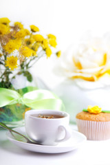 Obraz na płótnie Canvas breakfest with tea, cake and yellow flowers