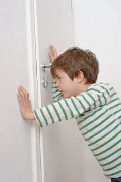 Kind guckt durch Schl&uuml;sselloch