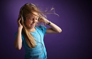 Girl with headphones on purple background