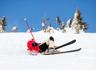 Girl skier falling down white on mountain slope