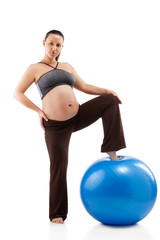 Pregnant woman doing exercises with gim ball, isolated on white