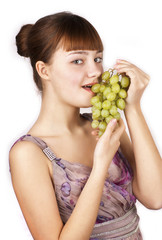 Young happy woman eating grapes