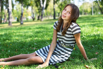 Naklejka na ściany i meble Young woman in summer park