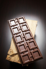 A tablet of chocolate on wood