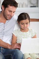 Father and daughter using computer together