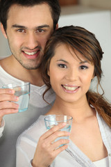 Enthusiastic man and woman with glasses of water