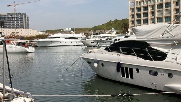 Marina. Luxury  yacht is moving toward the exit to the open sea