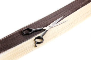 Shiny blond and brown hair with hair cutting shears isolated