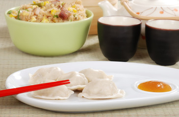 dumpling with plum sauce and chopsticks