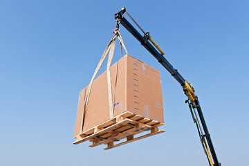 Crane elevating a box