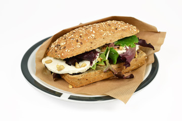 Roll ewe cheese with lettuce on a white context.