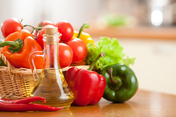 Sunflower oil in bottle and fresh vegetables in basket on the ta