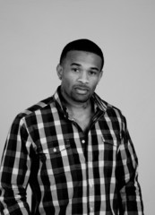 black man in plaid shirt looking at camera