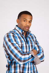 Black man in plaid shirt with his arms crossed