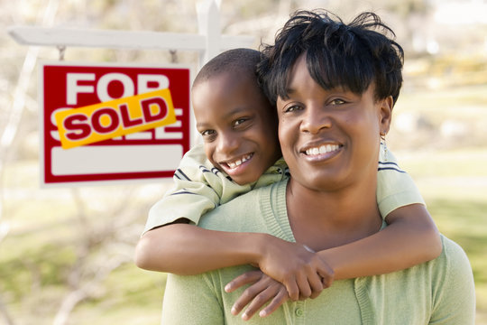 Mother and Child In Front of Sold Real Estate Sign