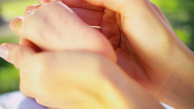Hands Cradling Baby Foot in Close up