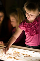 Girl paint with sand by finger