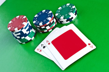 Counters and playing cards on a green background