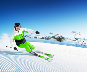 Skier in mountains, prepared piste and sunny day
