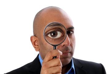 Mann mit Lupe vor Auge